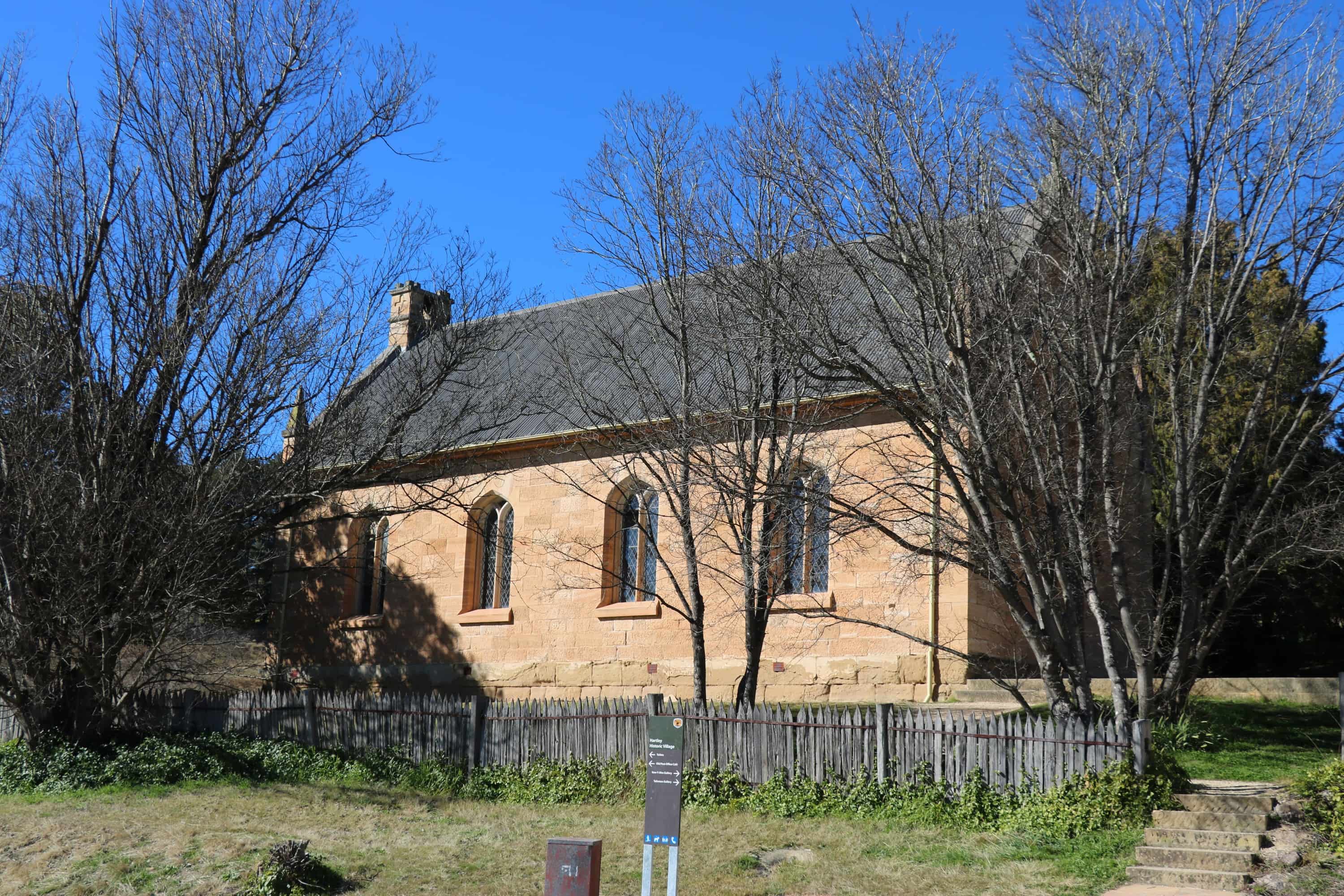 A sandstone building that forms part of the historic Hartley village with a backdrop of blue sky