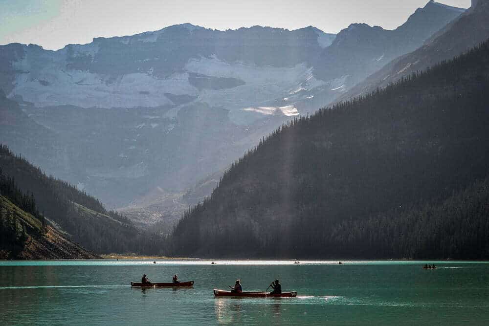 Canoes on a lake in between mountains
