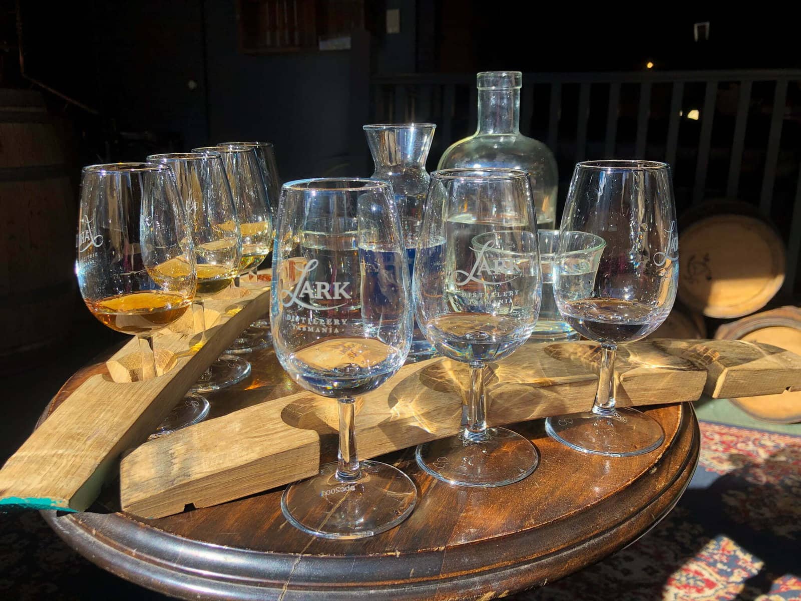 whiskey glasses on a wooden tasting paddle