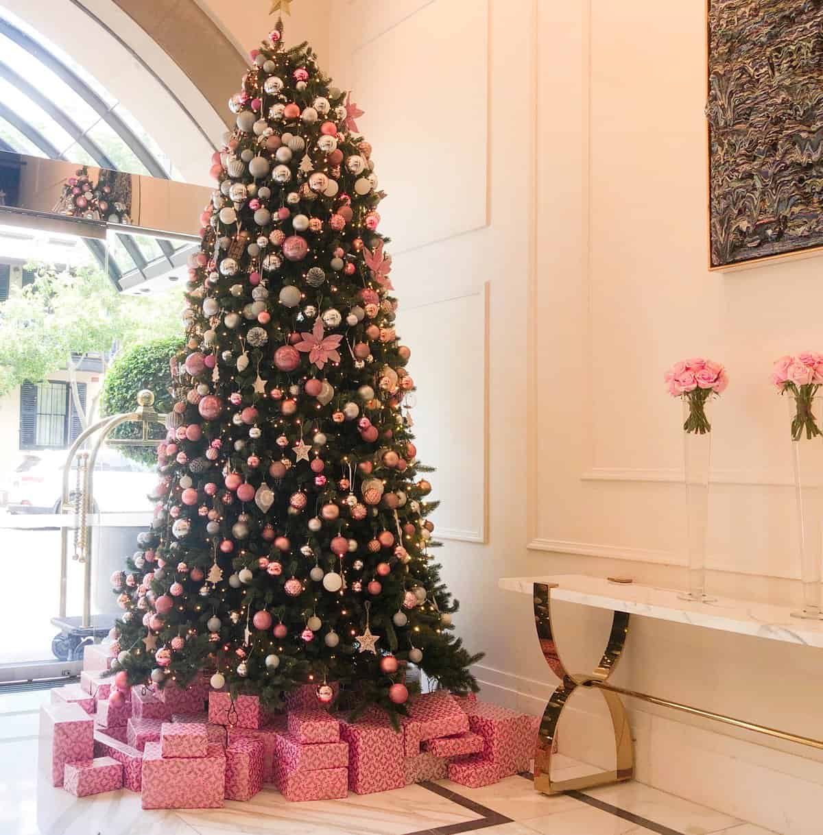 A tall Christmas Tree in the Langham foyer.  It is decorated with pink baubles and presents wrapped in pink paper