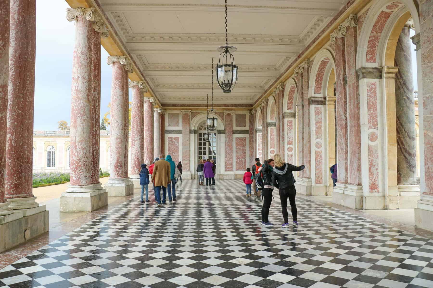 The checkerboard floor lined with archways  that marks the Grand Trianon entrance