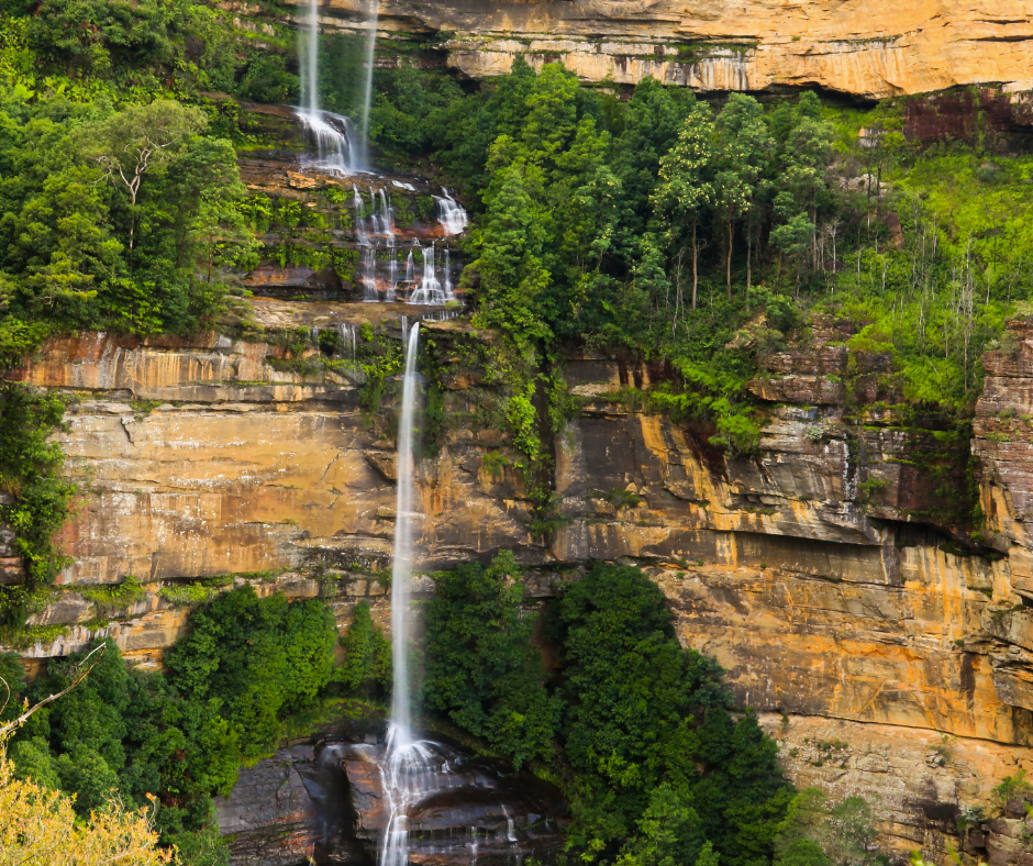 A two tiered waterfall tumbling over sandstone cliff