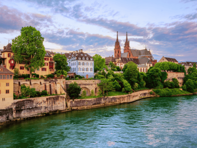 Vibrant view of Zurich cityscape with historic buildings, lush greenery, and the Limmat River in Switzerland during sunset. Perfect for travel inspiration and exploring Swiss architecture.